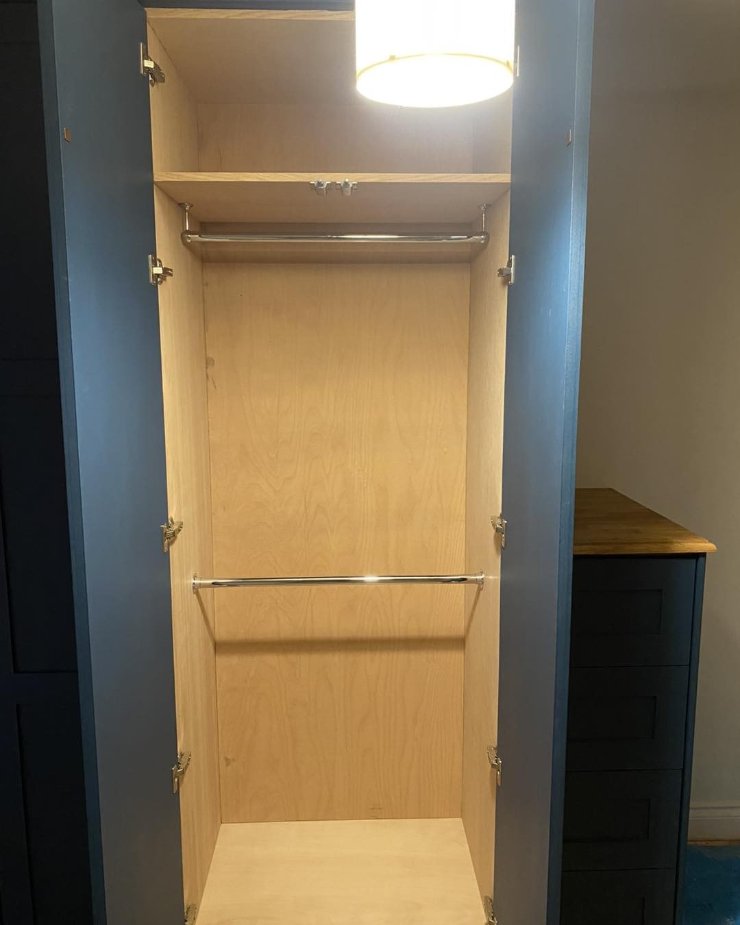 Inside a navy built-in wardrobe with a hanging rail