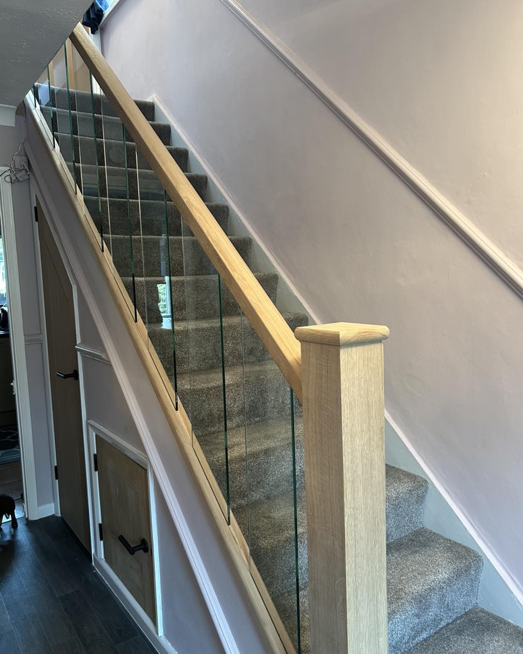 Oak handrail and toughened glass panels on a staircase