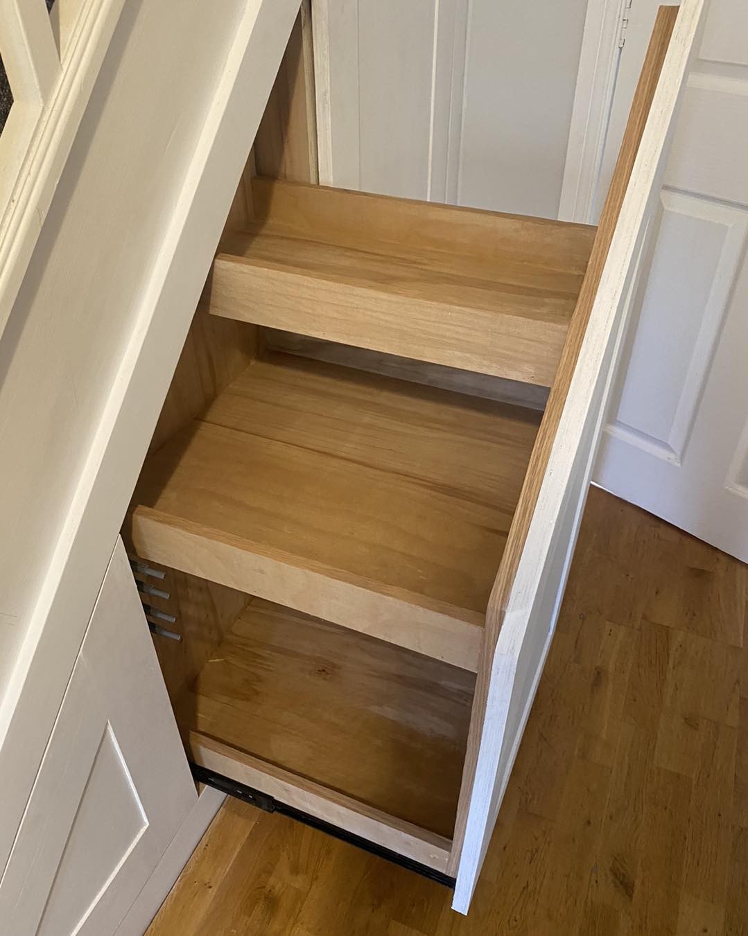 Under-stairs pull-out drawer with green shaker front and oak ply interior