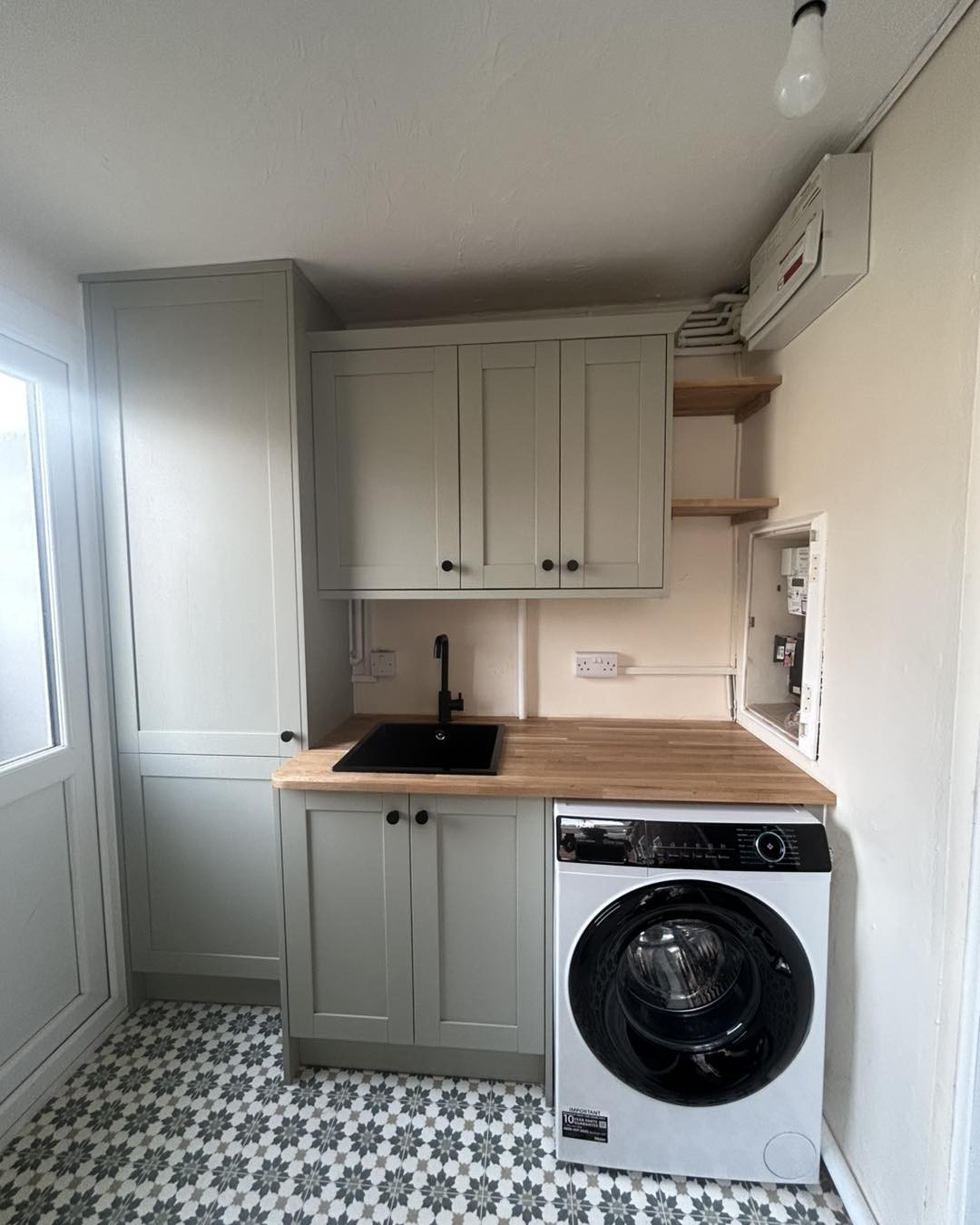 Utility room after: sage units with an oak worktop hiding the boiler