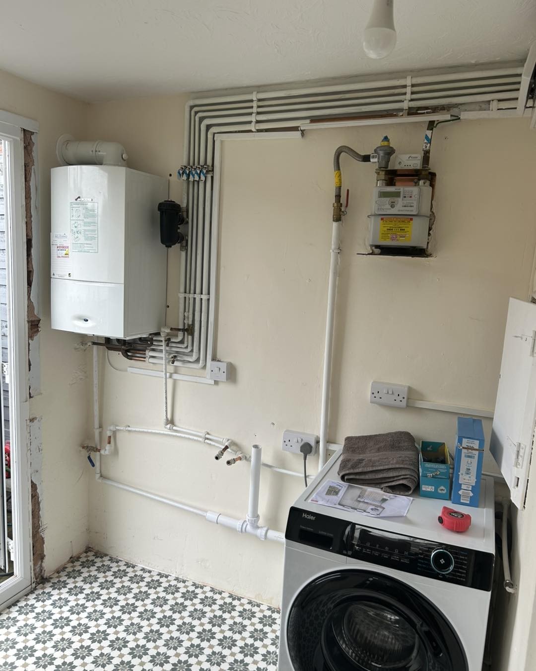 Utility room before: boiler, gas meter and pipework on show